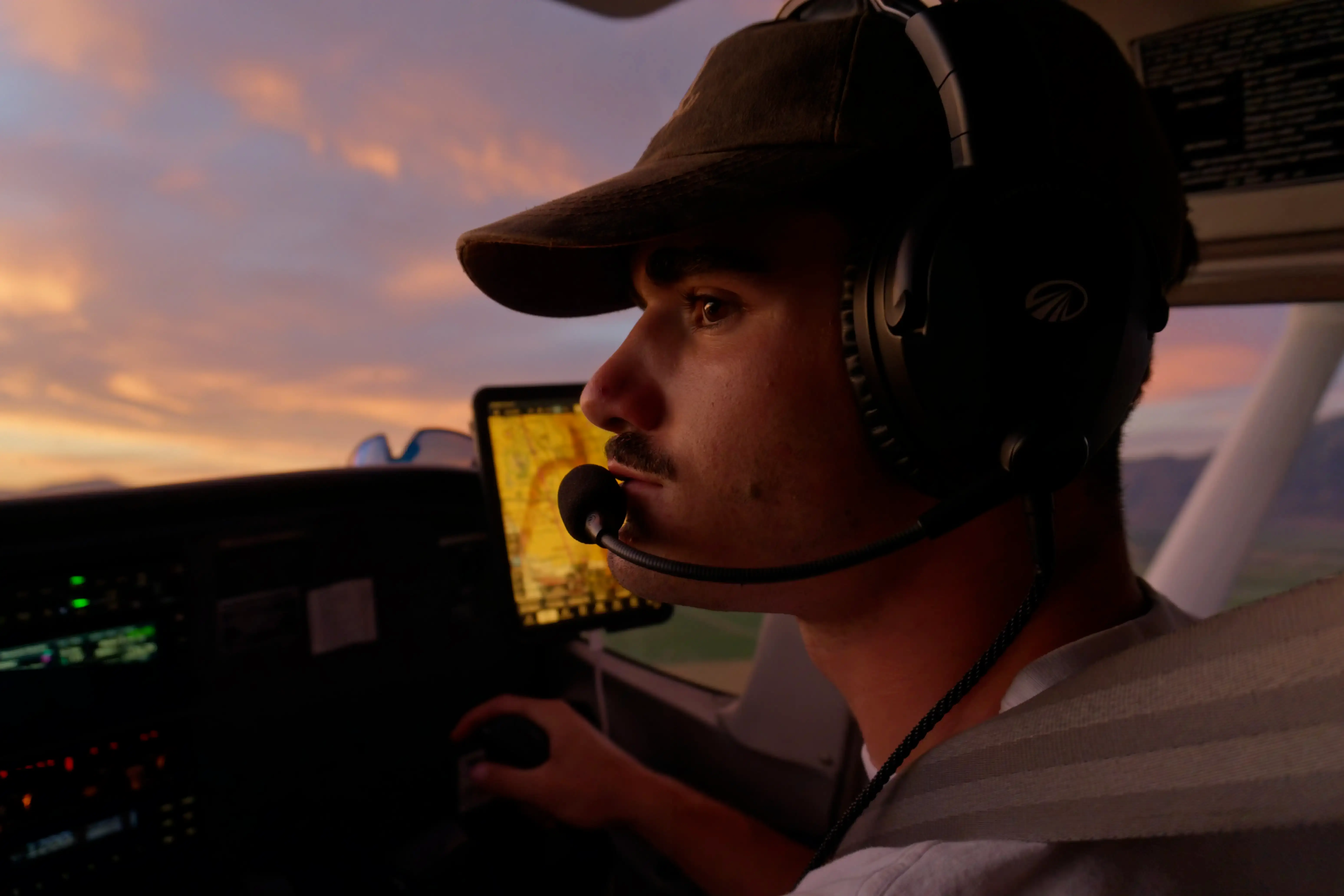 Men with headset looking forwards while piloting an aircraft