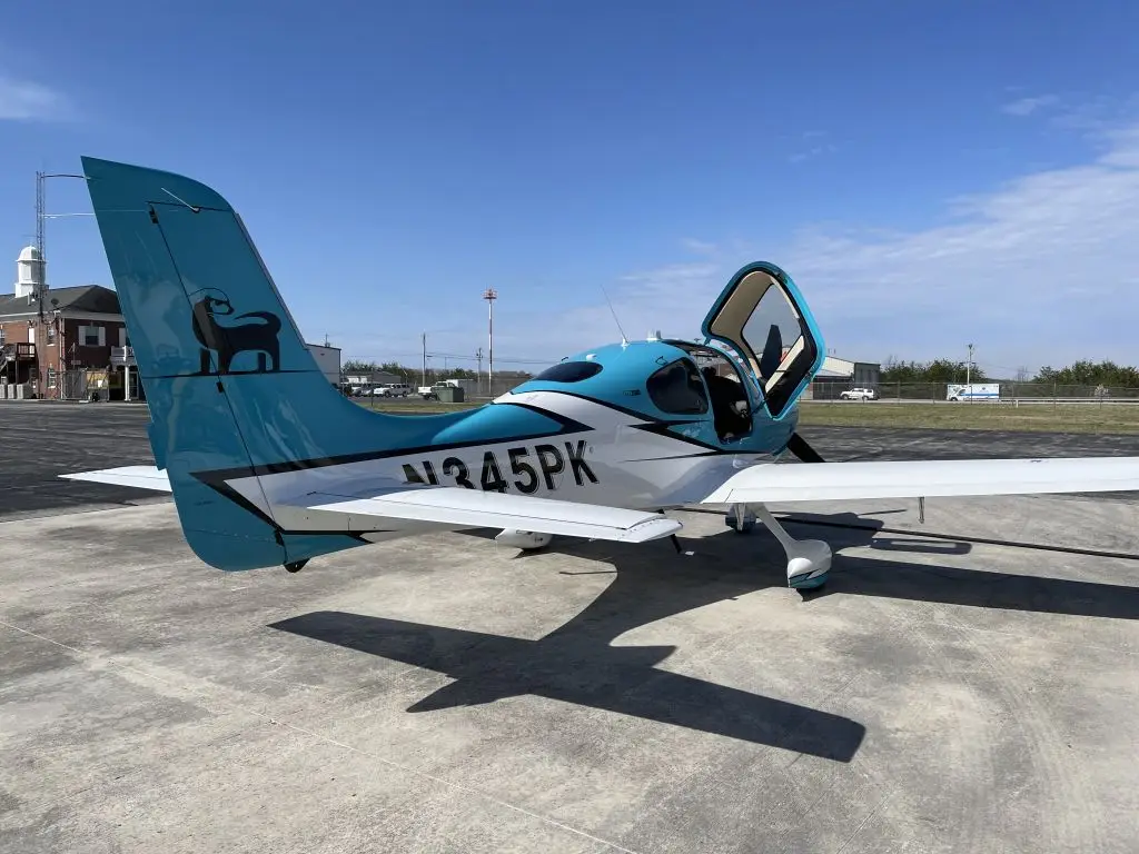 Back view of an aircraft with blue and white paint and the right door open