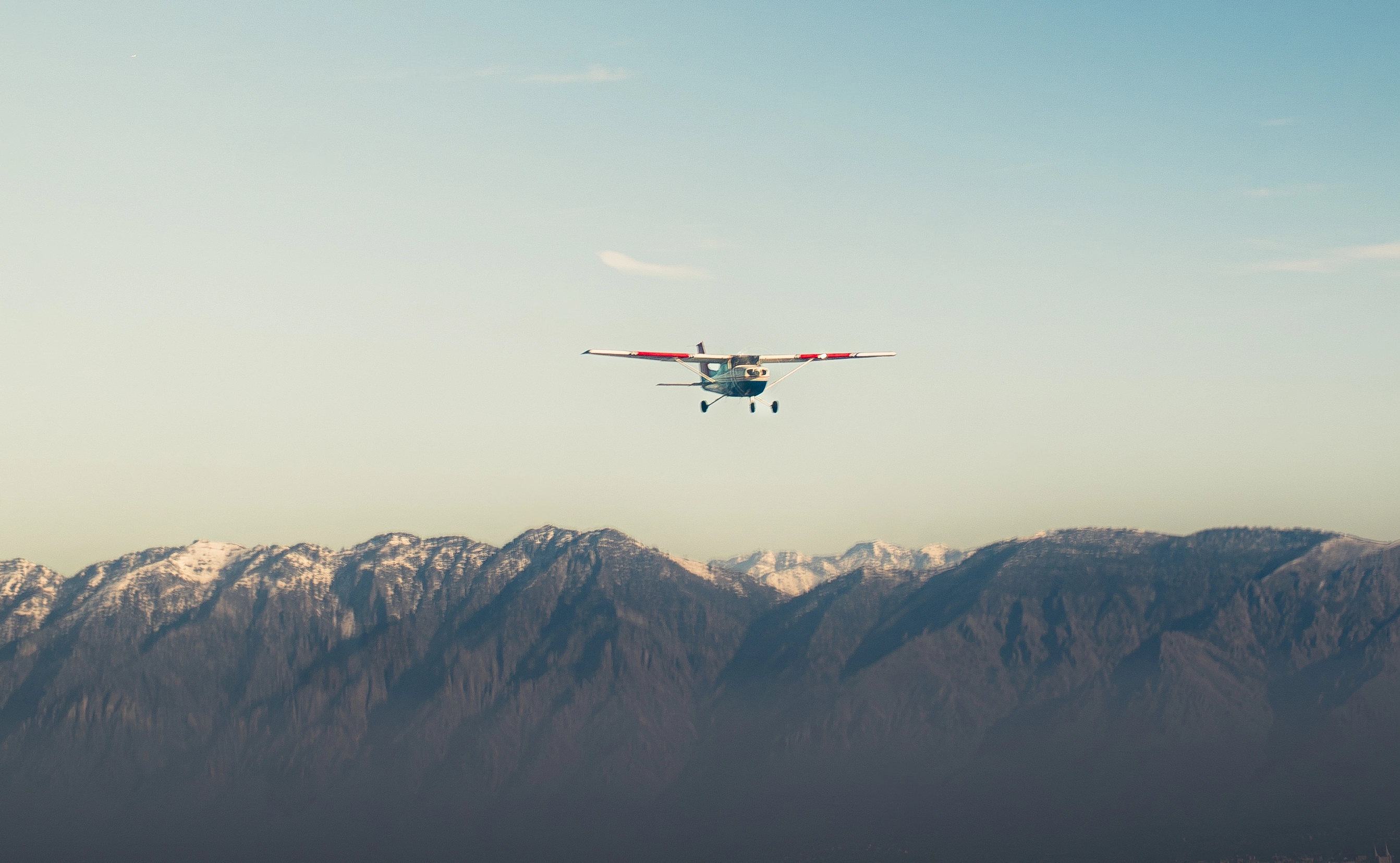 A plane flying up the montains